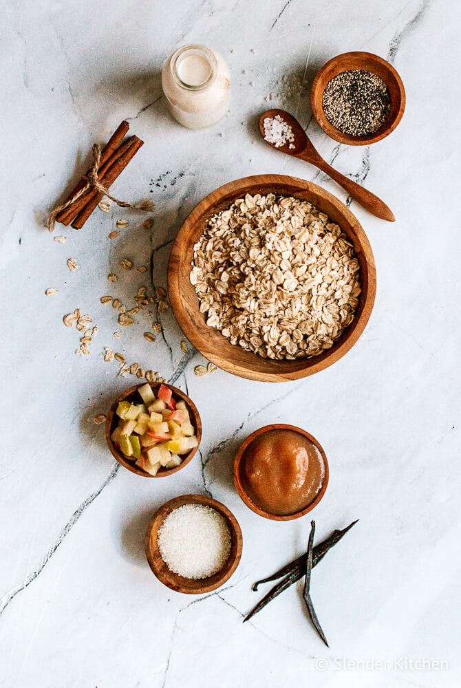 Overnight oatmeal ingredients including rolled oats, cooked apples, applesauce, cinnamon, vanilla, milk, and more.