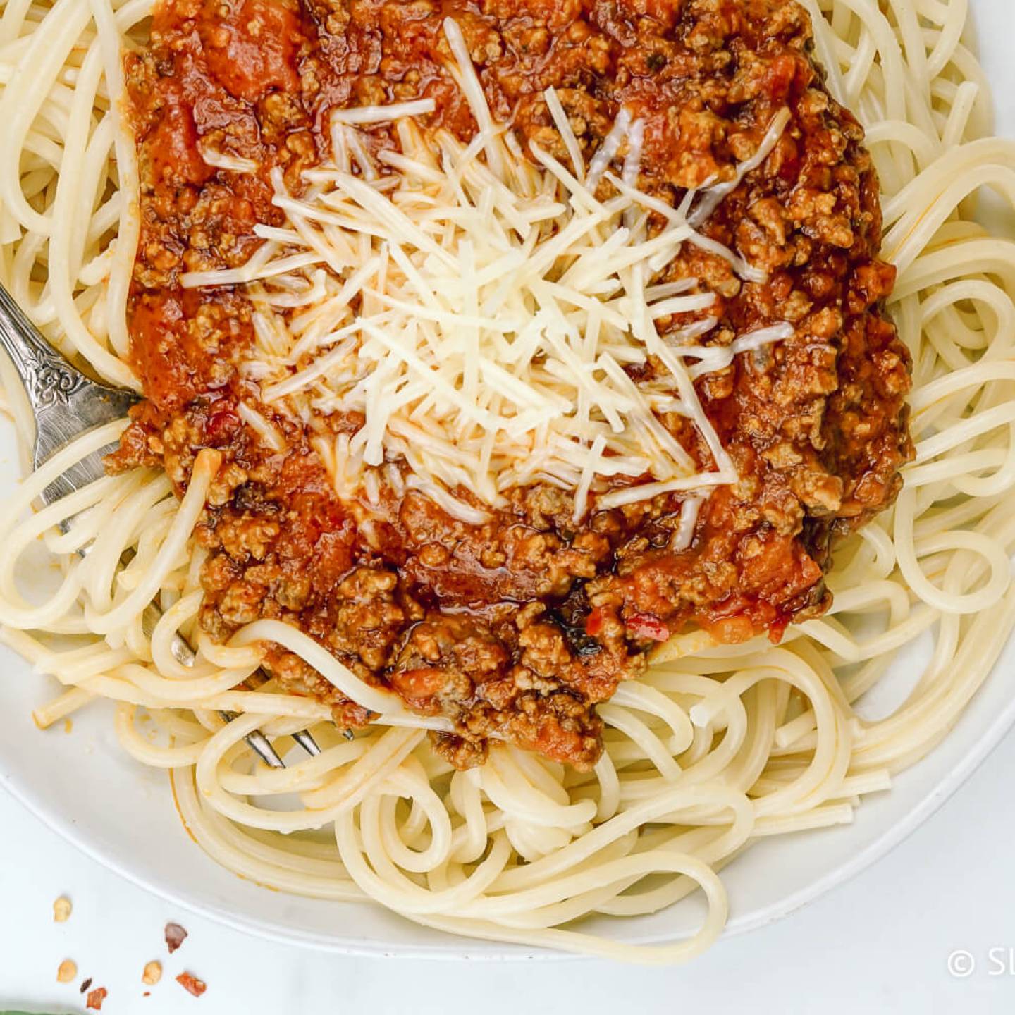 Spaghetti arrabiata with spicy tomato sauce served over a plate of pasta.