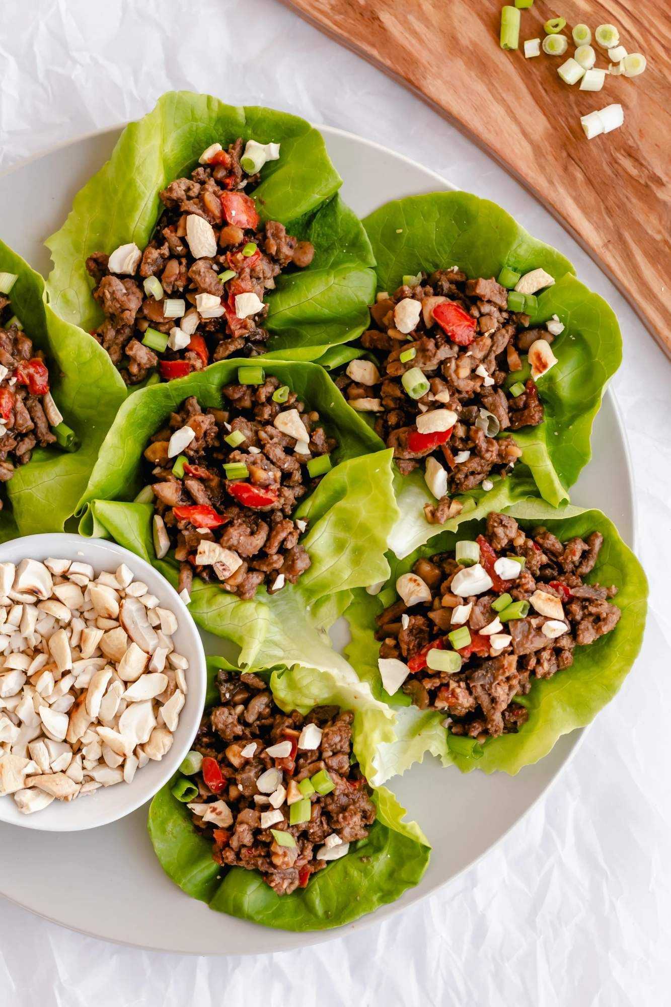 Ground beef lettuce wraps with Asian marinade in butter lettuce with chopped cashews on top.