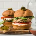 Asian turkey burgers with lettuce, tomato, and sweet chili yogurt sauce on two buns,