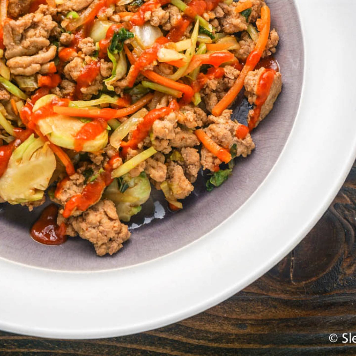 Whole30 Asian turkey stir fry with shredded cabbage, carrots, broccoli, and Brussels sprouts in a garlic, ginger, and soy based sauce. 