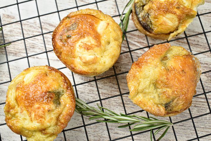 Asparagus frittata with mushrooms and feta cheese on a baking rack with rosemary.