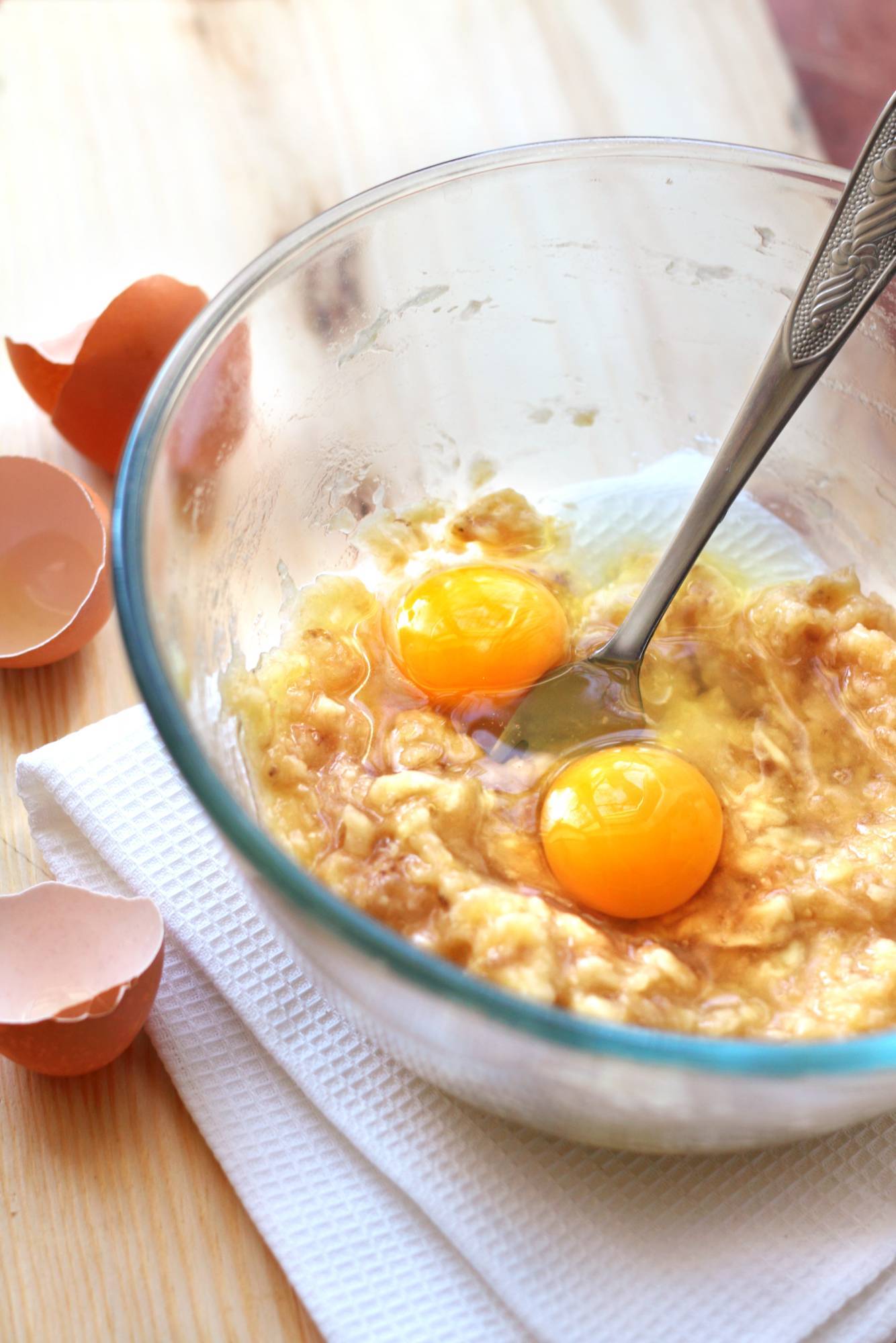 Egg and mashes banana pancake batter being made in a bowl.