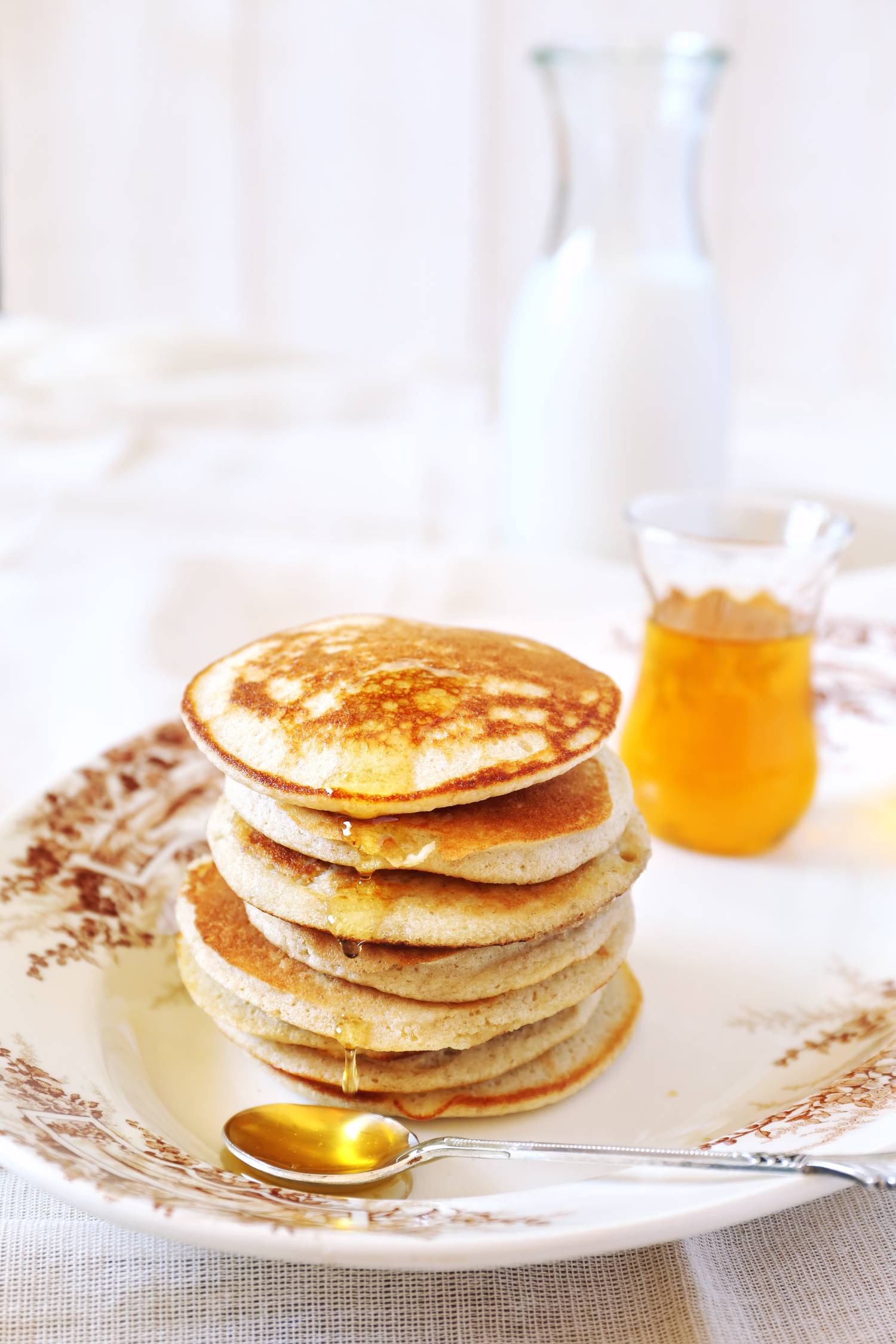 Three ingredient banana egg pancakes on a plate with maple syrup.