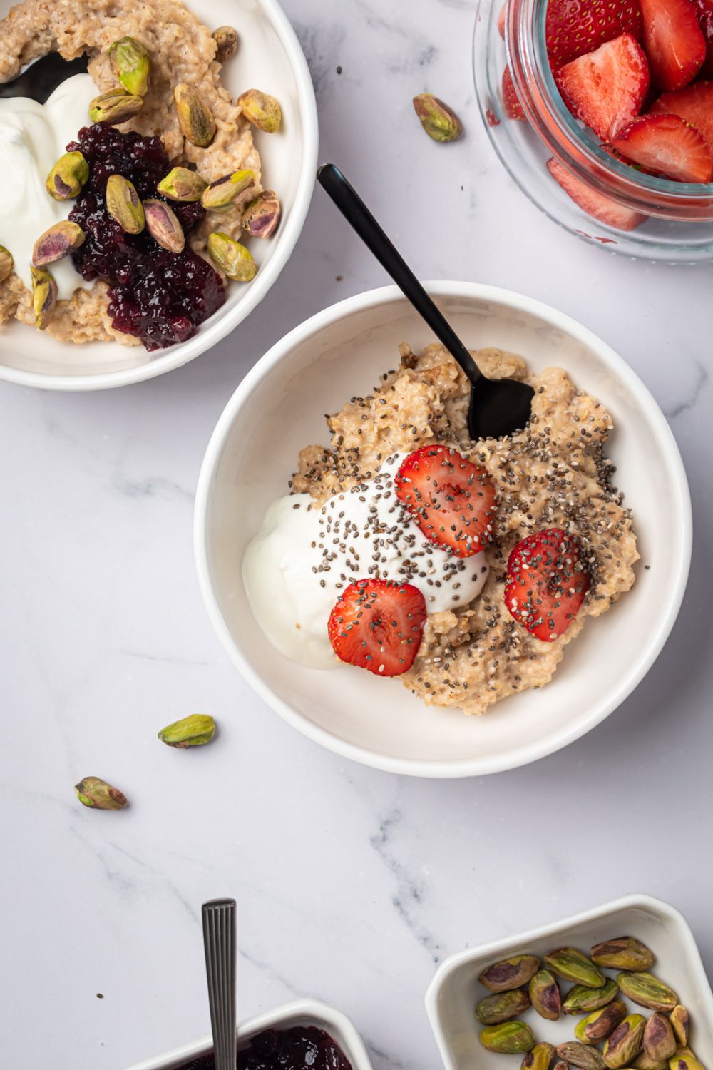 Tow bowls of microwave oatmeal topped with fresh fruit, chia seeds, and nuts.