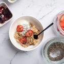 Microwave oatmeal with fresh fruit in a bowl with a spoon and Greek yogurt.