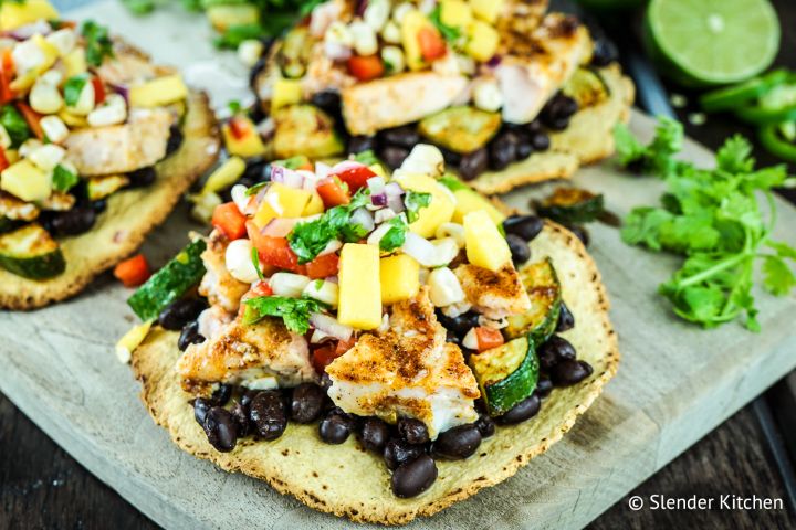 Salmon tostadas with blackened salmon, zucchini, veggies, and cheese on a crispy tortilla.