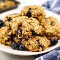 Blueberry breakfast cookies with rolled oats, bananas, fresh blueberries, chocolate chips, and chia seeds on a plate.