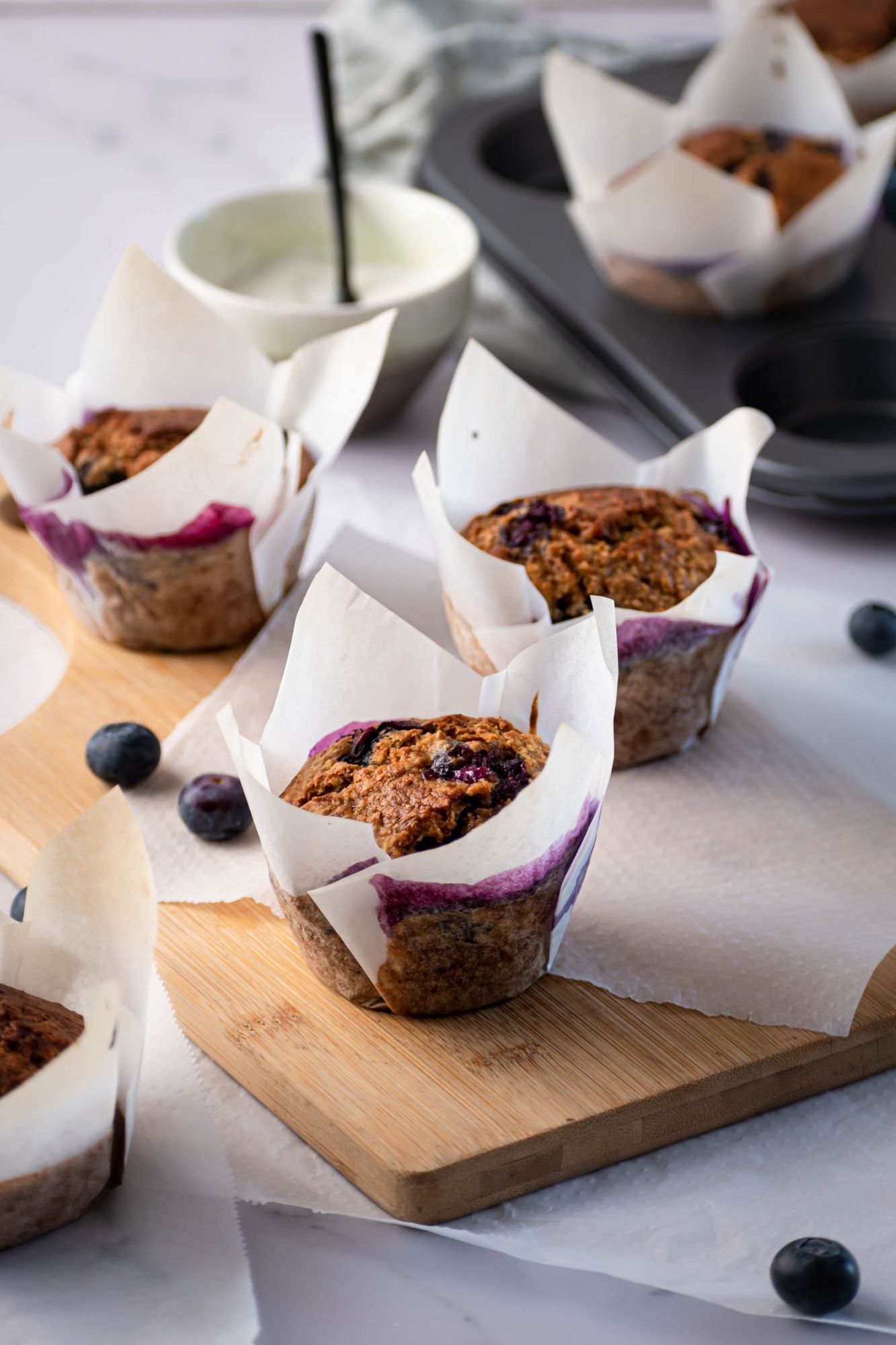 Oatmeal blueberry muffins made with rolled oats and fresh blueberries baked in parchment paper.