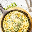 Butternut Squash and Spinach Breakfast Casserole in a cast iron skillet with a napkin.