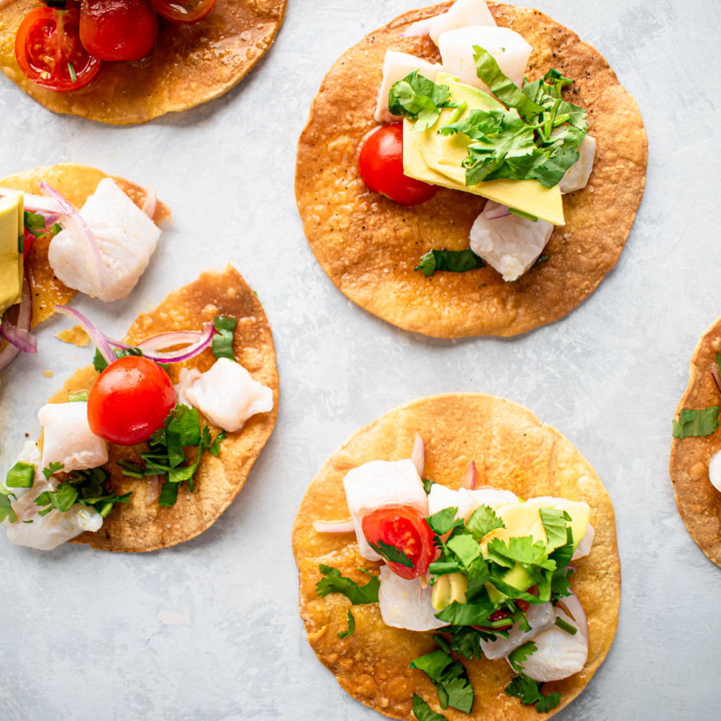 Ceviche tostadas with fish ceviche on a baked tostada shell topped with avocado and cilantro.