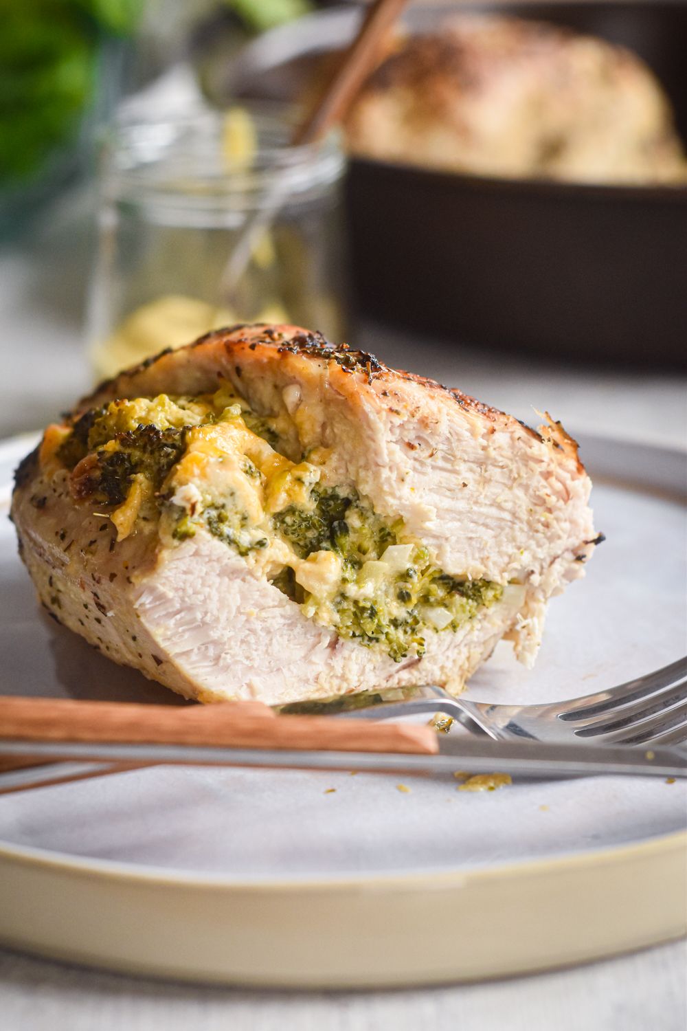 Chicken breasts stuffed with broccoli, cheddar cheese, and cream cheese sliced on a plate.