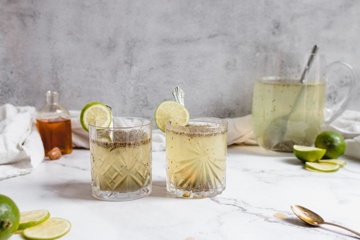 Chia fresca with water, lime juice, chia seeds, and honey in two glasses served with fresh lime slices.