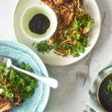 Chicken and cabbage stir fry on two plates with hoisin sauce, cilantro, chopped cabbage, and chicken breast.