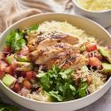 Chicken taco bowls with sliced grilled chicken, pico de gallo, avocado, cilantro, and rice.