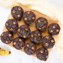 Chocolate banana muffins made with ripe bananas on a wooden board with chocolate chips.