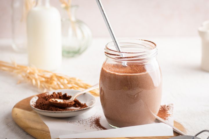 Chocolate breakfast shake with tofu, almond milk, and bananas in a mason jar with whipped cream.