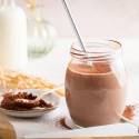 Chocolate breakfast shake with tofu, almond milk, and bananas in a mason jar with whipped cream.