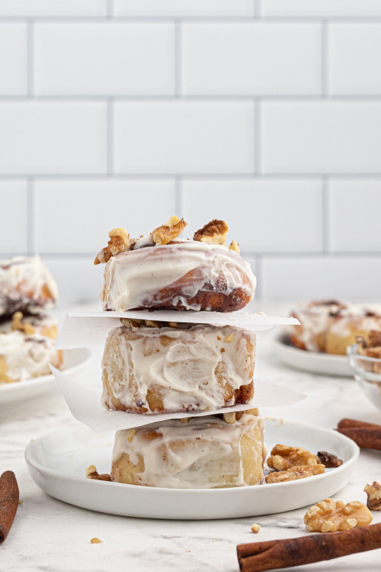 Homemade cinnamon rolls stacked on a plate with cream cheese icing and cinnamon filling.