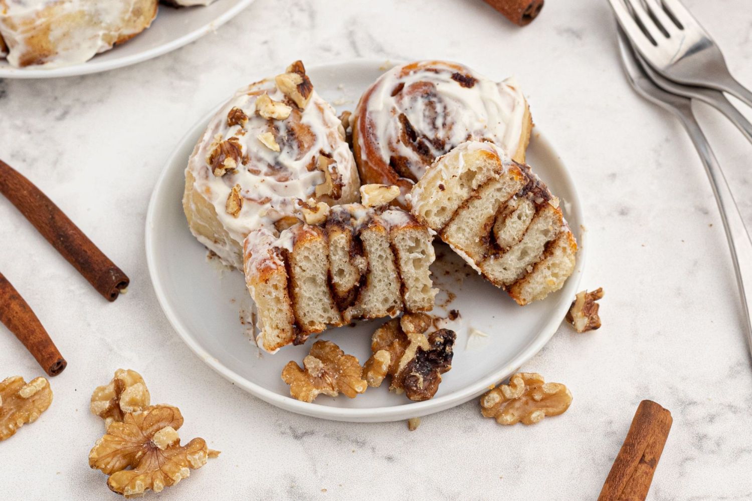 Two ingredient dough cinnamon rolls sliced in half on a plate to see the cinnamon swirls inside.