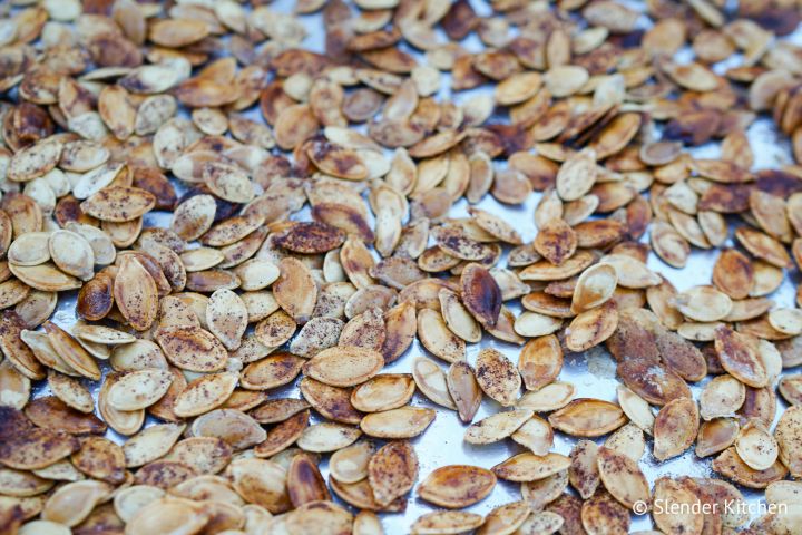 Roasted cinnamon sugar pumpkin seeds on a sheet pan.