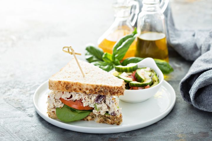 Cranberry almond chicken salad sandwich on whole wheat bread with lettuce and tomato.