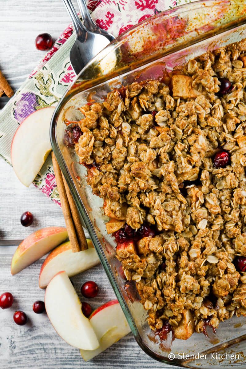 Apple Cranberry Baked Oatmeal in a glass baking dish with two spoons.