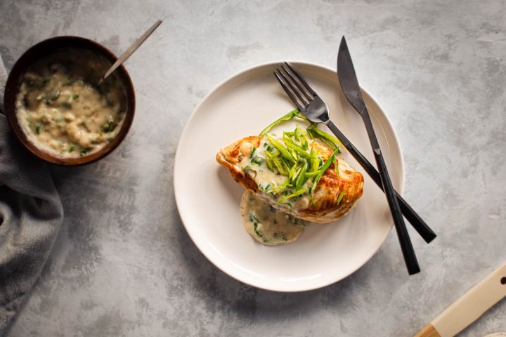 Creamy jalapeno chicken seared in a pan and topped with a jalapeno cream sauce on a plate.