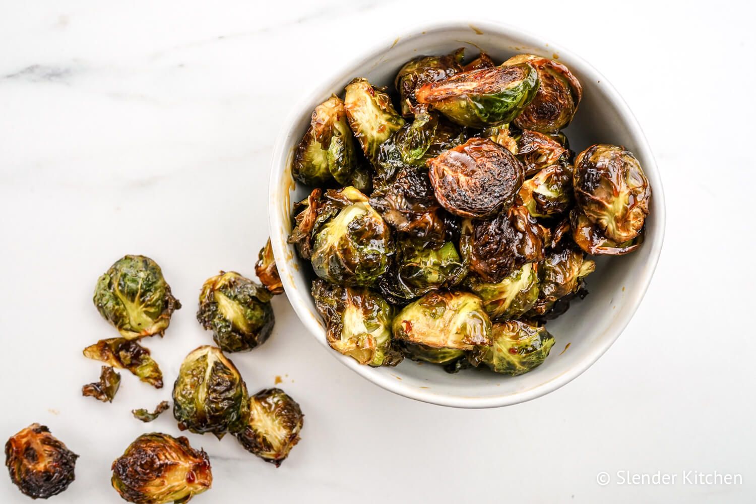 Roasted Asian Brussel sprouts in a bowl with a soy honey sauce.