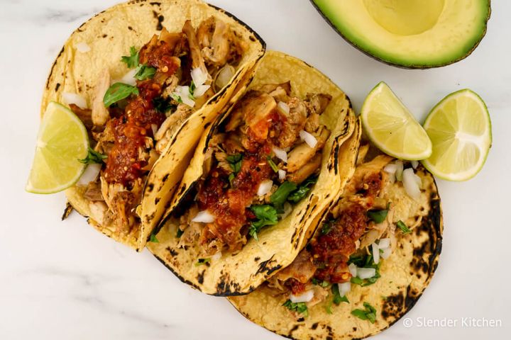 Carnitas in a corn tortilla with salsa, onion, and cilantro.