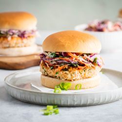 Salmon burgers with fresh salmon and spices served on a bun with coleslaw.