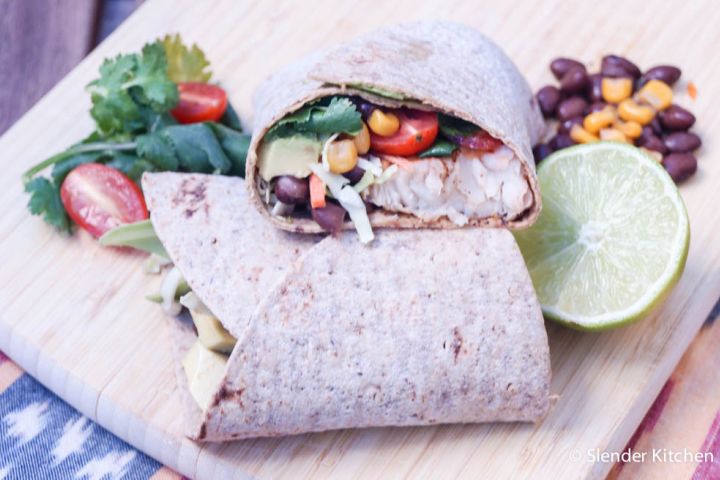 Fish burritos with ancho tilpaia, black beans, corn, cabbage, and cilantro a plate.