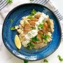 Grilled lemon chicken breast with tzatziki on a bed of rice. 