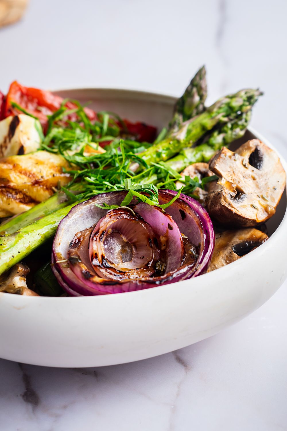 Bowl with grilled asparagus, red onion, mushrooms, bell peppers, and zucchini. 