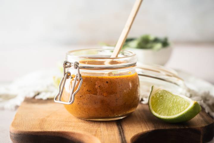 Habanero salsa made with roasted habanero peppers, garlic, citrus juice, and tomatoes in a small glass jar.