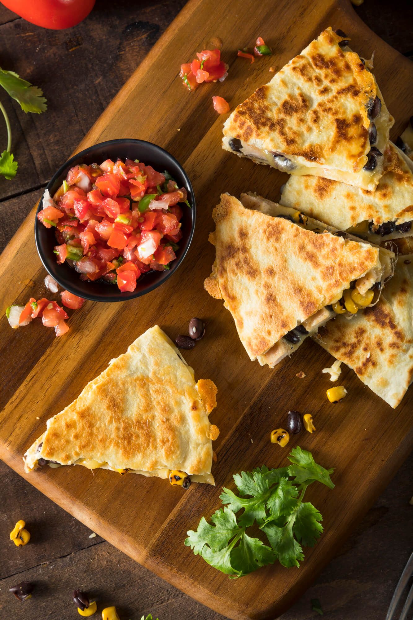 Healthy Chicken Quesadillas cut into pieces with tomatoes and cilantro.