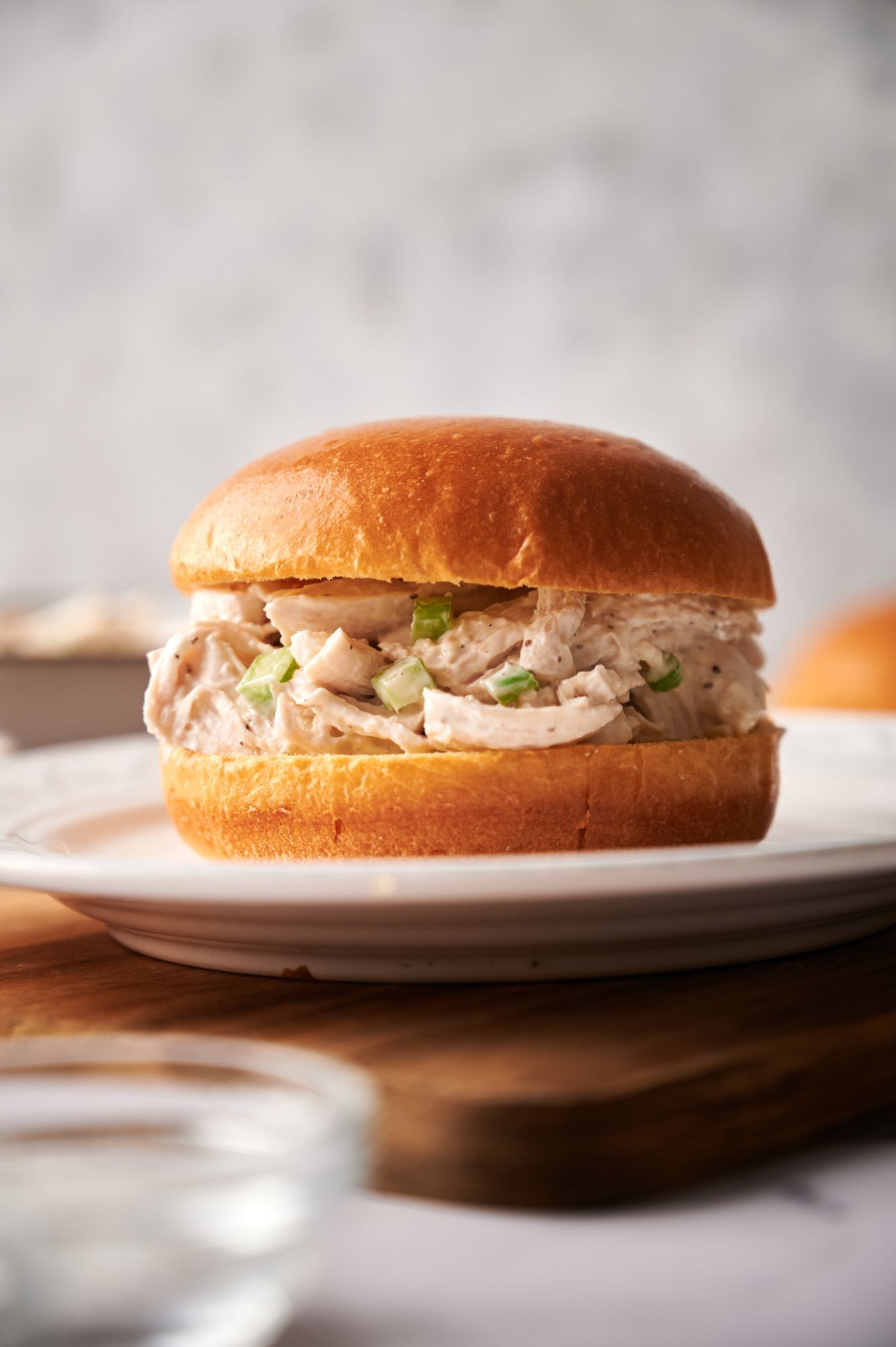 Healthy chicken salad sandwich with shredded chicken, celery, and yogurt dressing on a white roll.