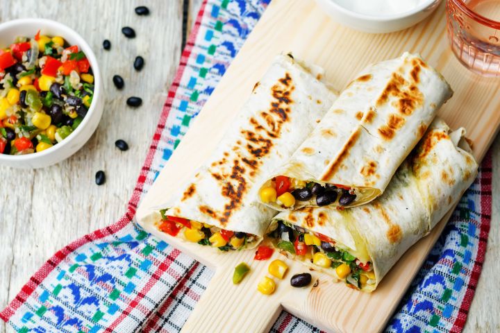 Homemade frozen burritos with beans, rice, and vegetables on a plate.