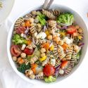 Vegetable pasta salad with cooked whole wheat pasta, chopped fresh vegetables, chickpeas, and feta cheese topped with lemon dressing.