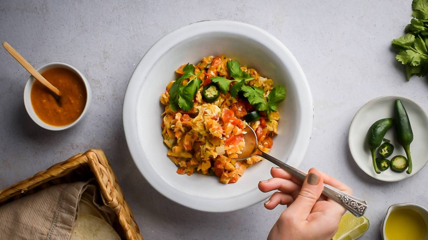 Mexican scrambled eggs with tomatoes, chile peppers, and onions in a bowl with cilantro.