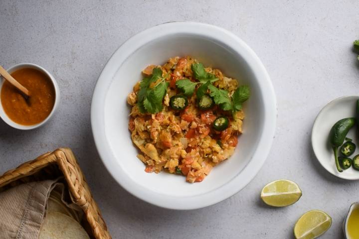 Huevos a la mexicana with scrambled eggs, tomatoes, onions, jalapenos, and cilantro in a bowl.