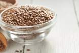 Bowl with flax seeds on a white surface