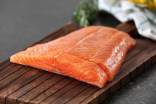 Salmon meat on brown chopping board