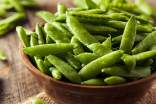 Fresh sugar snap peas on a wooden bowl