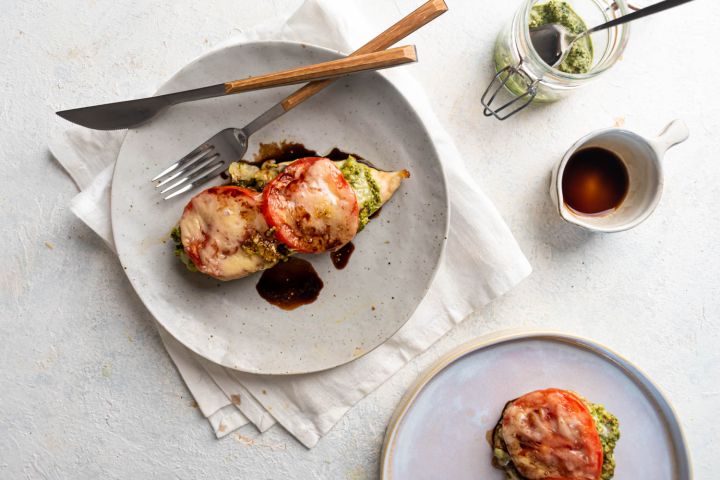 Italian pesto chicken baked with sliced tomatoes and melted cheese with a drizzle of balsamic vinegar.