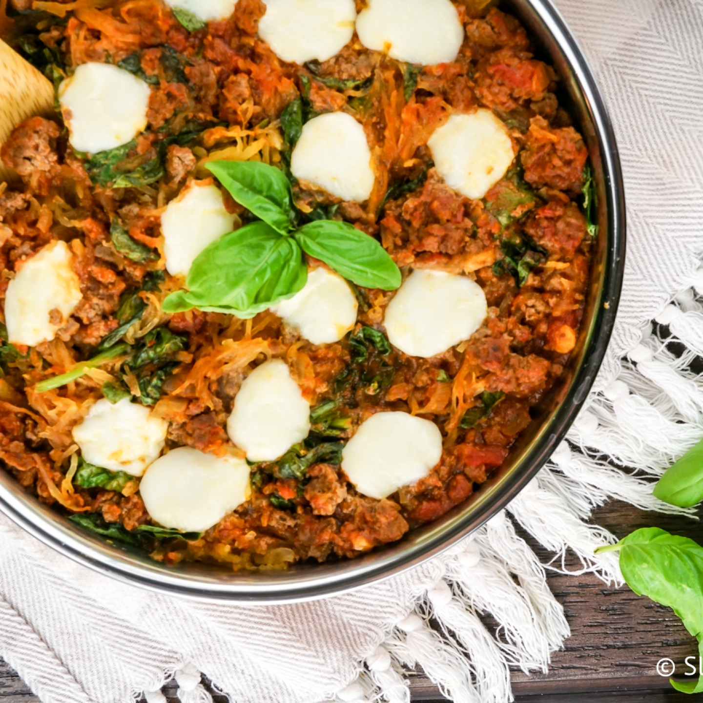 Spaghetti squash casserole with tomatoes, ground beef, and fresh mozzarella cheese.