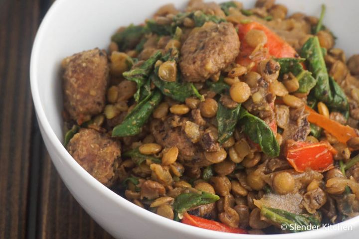 Lentils with sausage, spinach, and tomatoes in a bowl. 