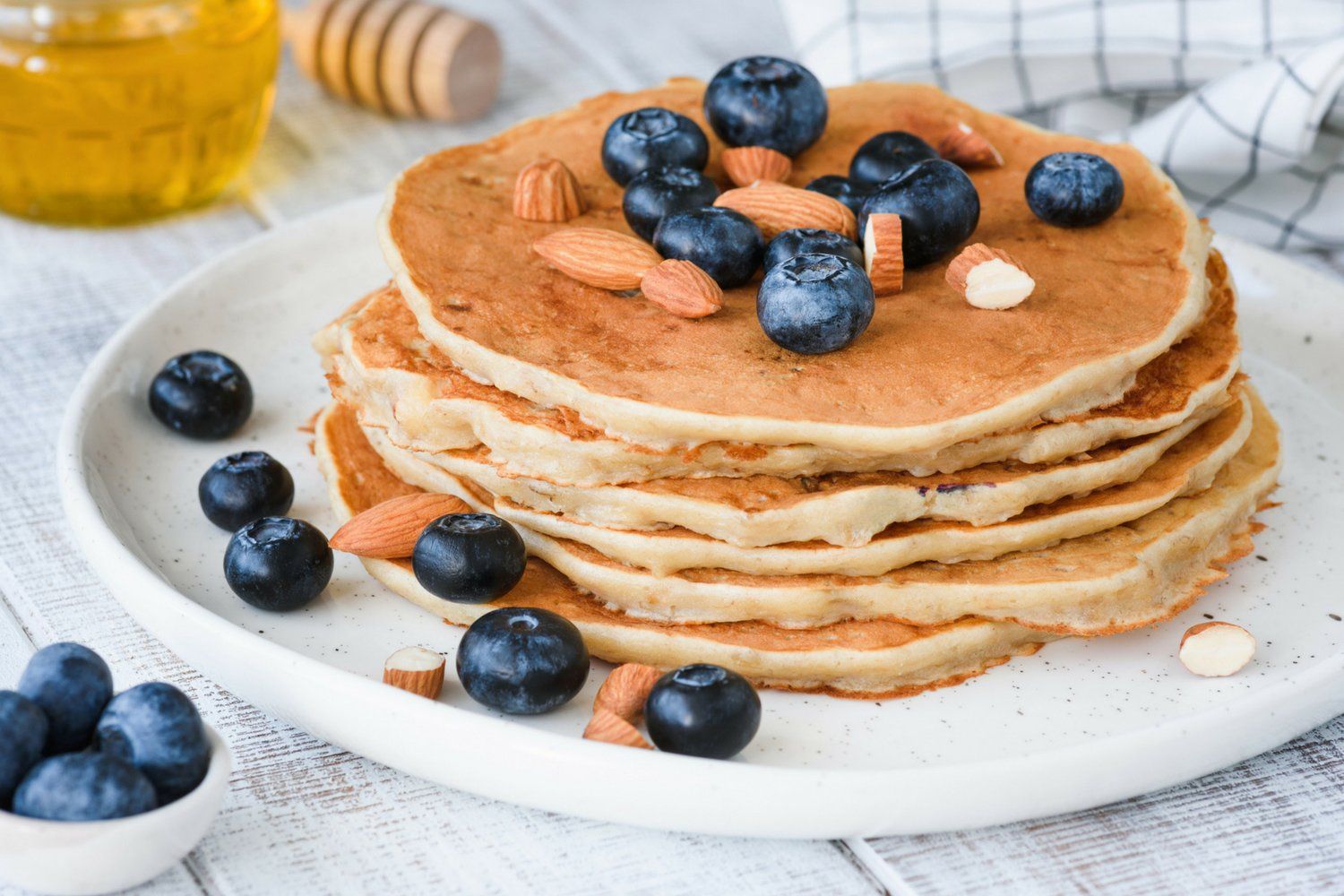 Low carb pancakes on a plate with blueberries and almonds.