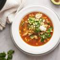 Mexican chicken soup with shredded chicken, corn, onions, avocado, cilantro, and queso fresco.