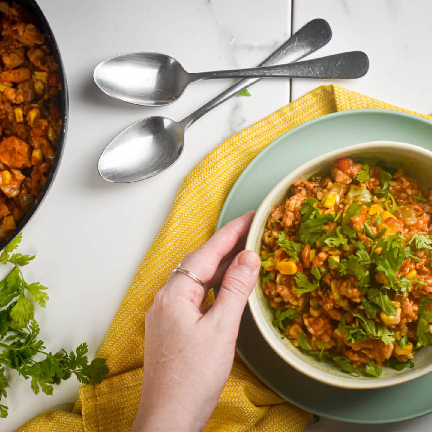 Turkey taco skillet with beans, corn, ground turkey, and rice in a bowl with cilantro and green onions.